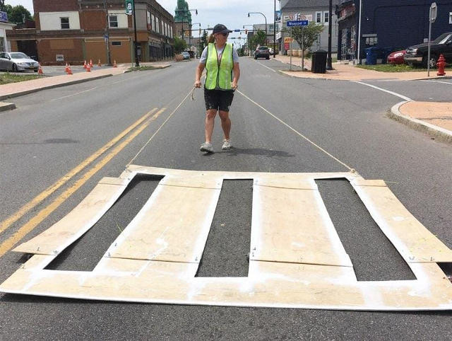 photo of Rebecca dragging a crosswalk stencil into place