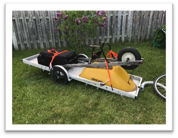 trailer with upside-down wheelbarrow and toolbox on trailer